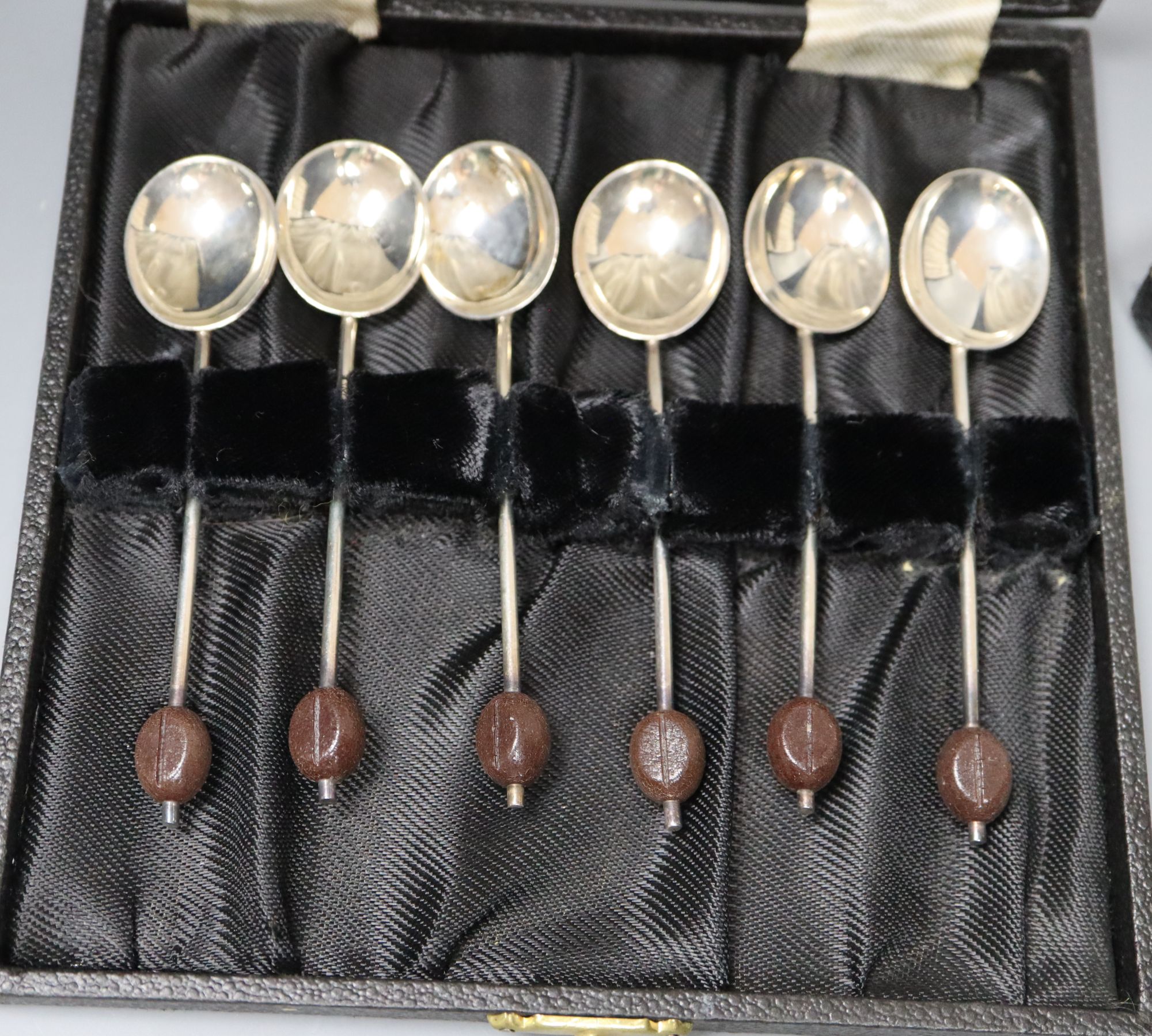 A 1930s cased set of six bean end silver coffee spoons and a later set of six silver grapefruit spoons.